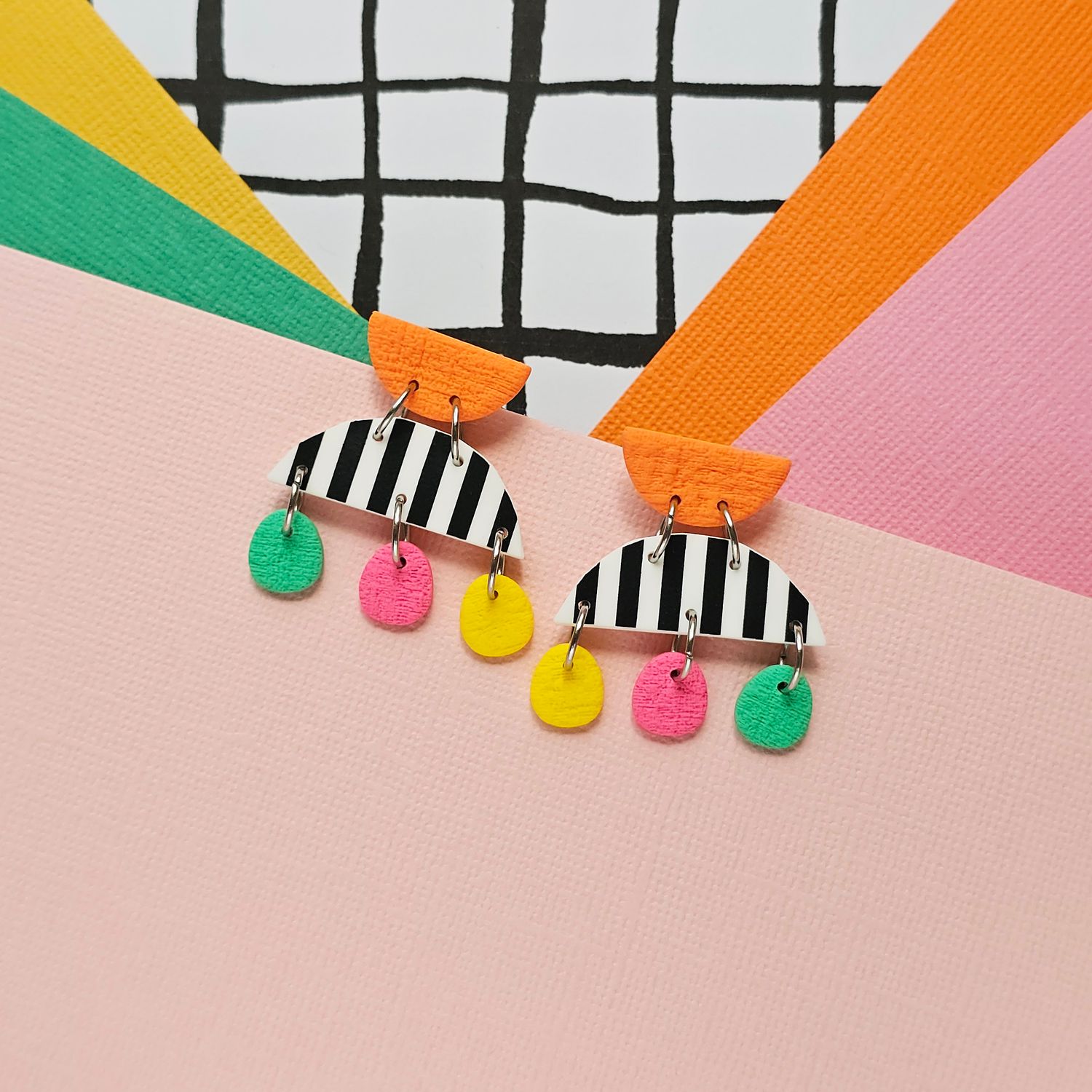 A pair of small polymer clay earrings with stripes and colourful beads