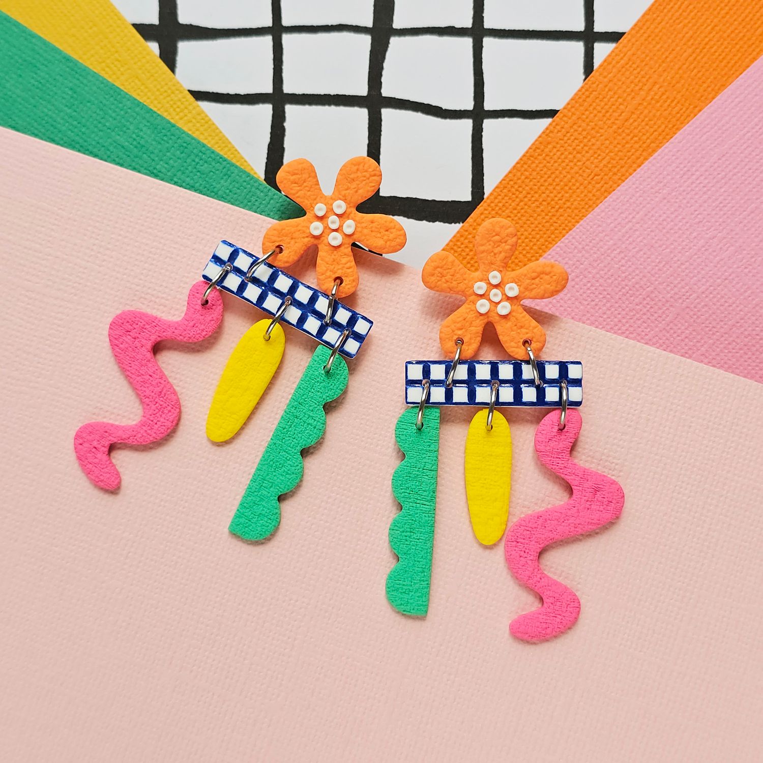 A pair of colourful playful dangly polymer clay orange flower studs