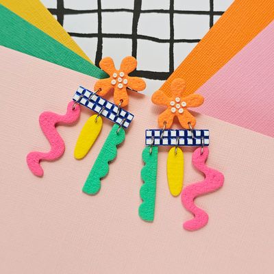 A pair of colourful playful dangly polymer clay orange flower studs