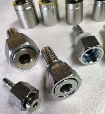 Various sizes of female ORFS Hydraulic Hose Fittings with ferrules in the background ORFS stands for O Ring Face Seal