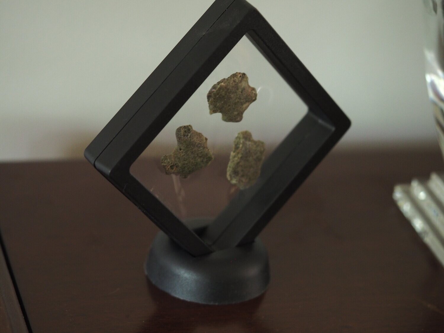 3 pieces of Trinitite in a black 3D frame