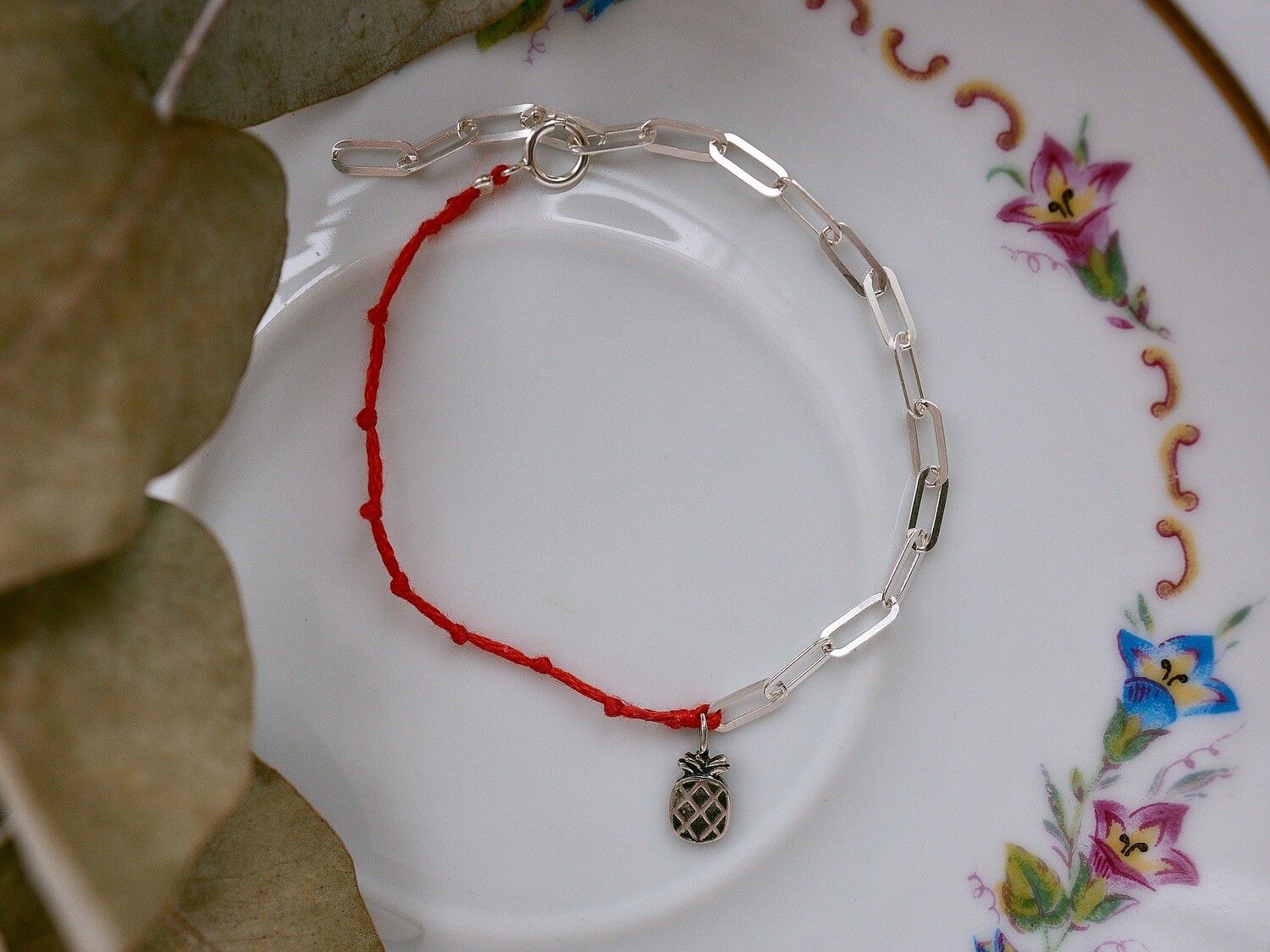 A silver bracelet with a pineapple charm