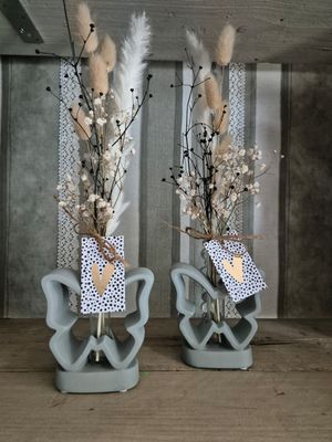 betonnen vlinder met droogbloemen