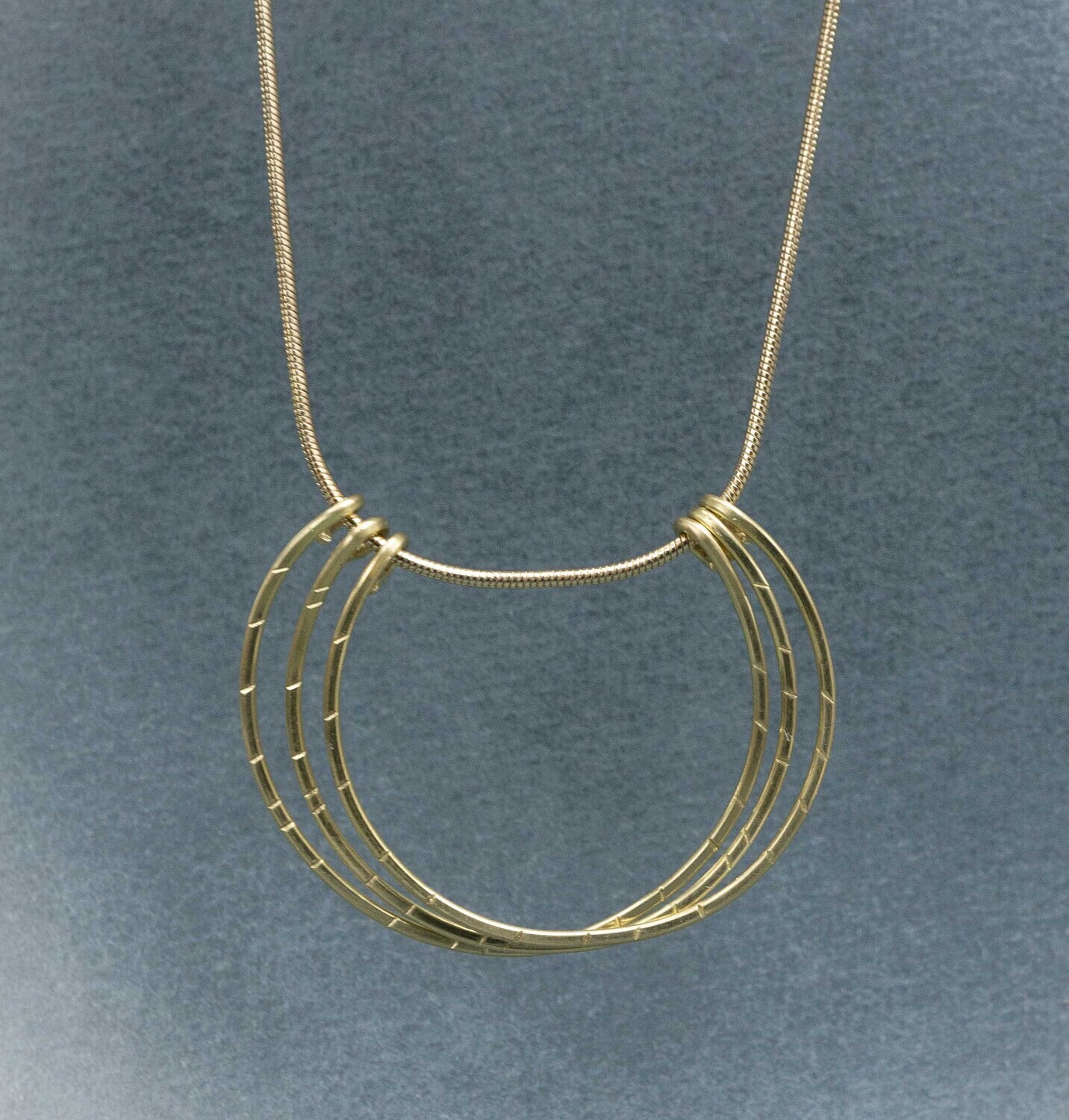 A minimalist brass necklace with 3 textured half hoops.  The chain is adjustable.