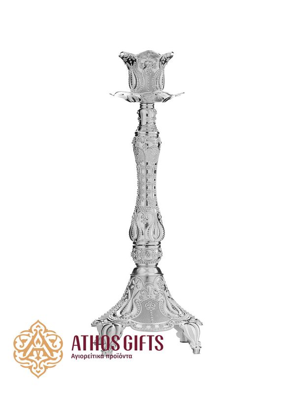 Metal candlestick for a single candle, decorated with a carved ornament.