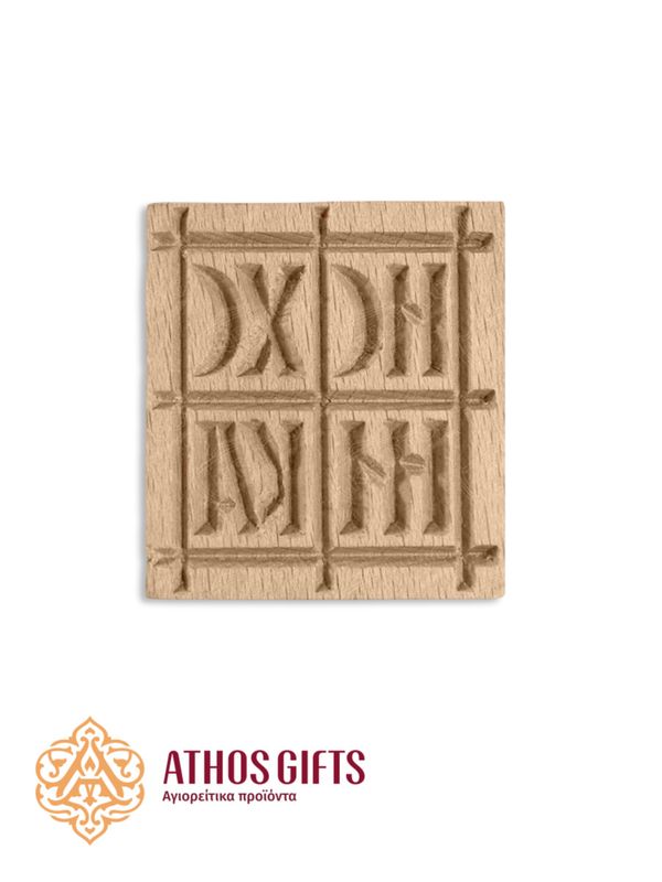 A wooden stamp for creating patterns on prosphora, featuring a cross and the engraving “IC XC NIKA”.