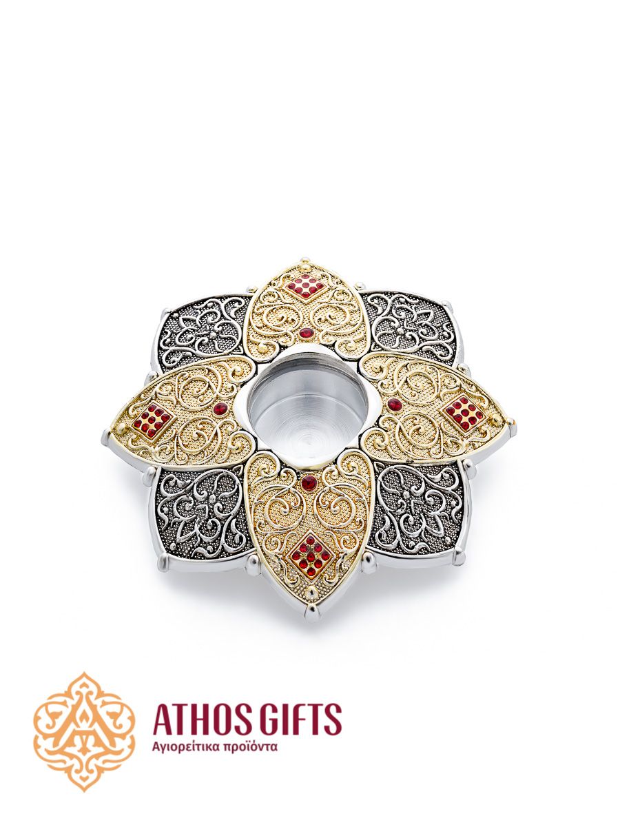 A miniature metal reliquary with a viewing window, decorated with a floral ornament.