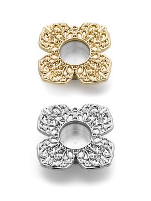 A miniature metal reliquary with a viewing window, decorated with a floral ornament.