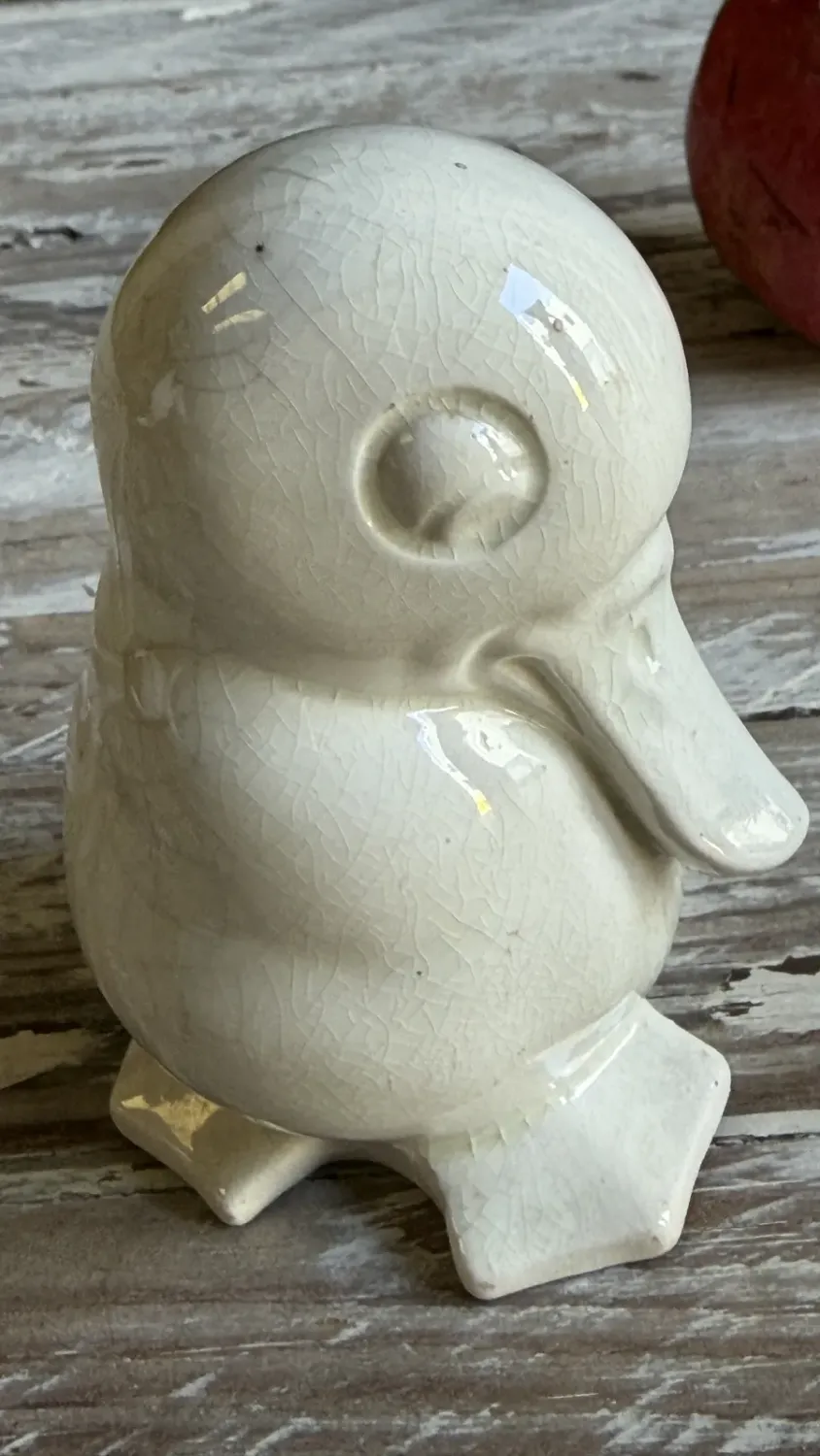 White maiolica duckling seen from three quarters, beak visible