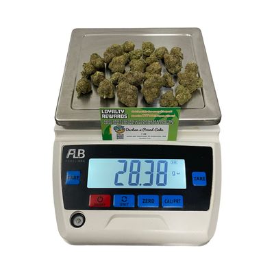 Durban x Pound Cake cannabis flower ounce on digital scale showing weight – premium hybrid strain with vanilla and citrus notes
