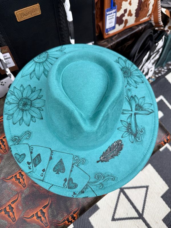 Turquoise one of a kind burned western hat with sunflowers. This hat also includes a cross and leather feather.