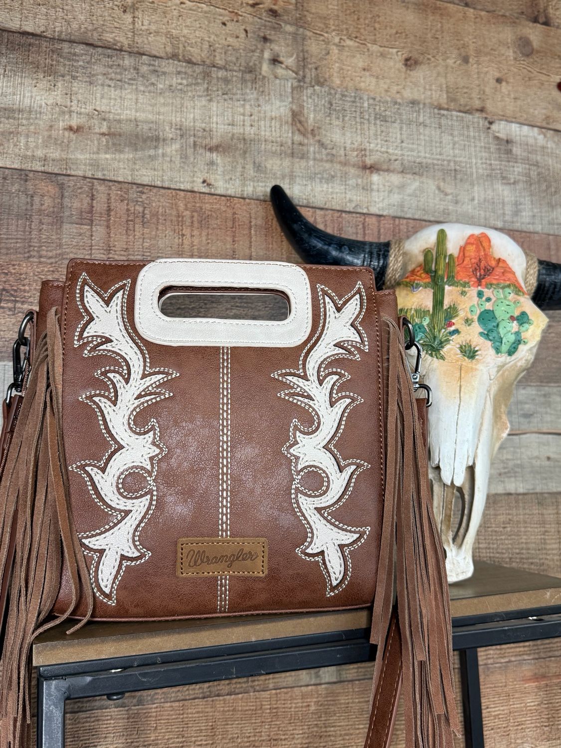 This Wrangler western style boot scroll crossbody bag with fringe will make a statement with all your outfits. Medium size 