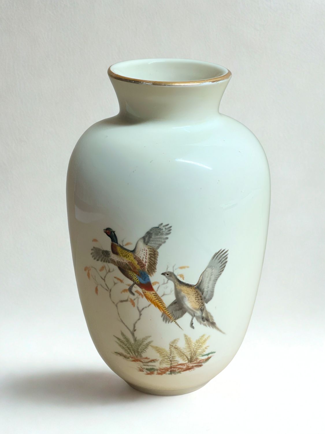 Vintage Waechtersbach porcelain vase with hand-painted pheasants flying among heathers on a cream background with gold rim.