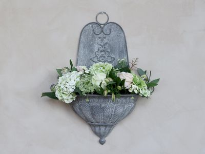 French-style ornate zinc wall planter filled with Spring faux florals adding a unique piece of wall art indoors