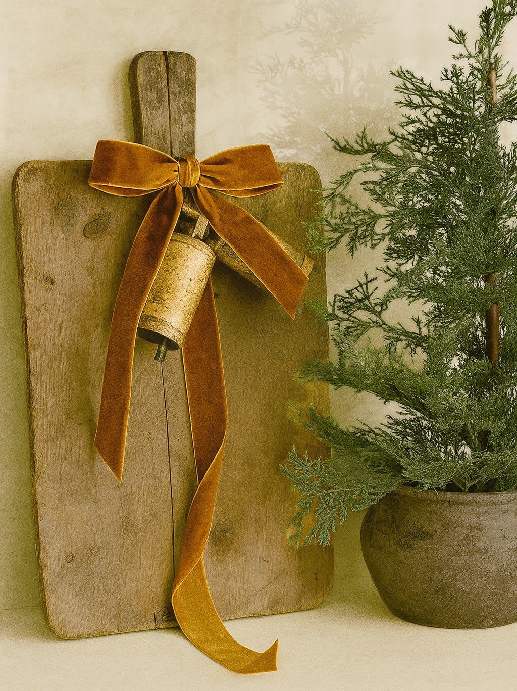 Copper Velvet Ribbon tied in a bow with vintage bells adding a touch of festive flair to a rustic wooden chopping board