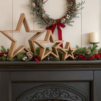 Wooden Mantle Stars - Set of 3 Three Wooden Mantlepiece Stars on Cast Iron Fireplace adding a rustic Christmas theme to your home