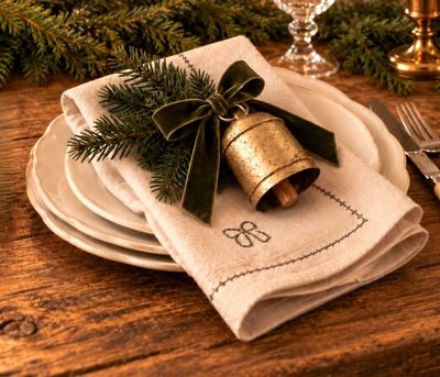Rustic linen napkin with embroidered bow and stitched trim—adds charm to Christmas place settings.