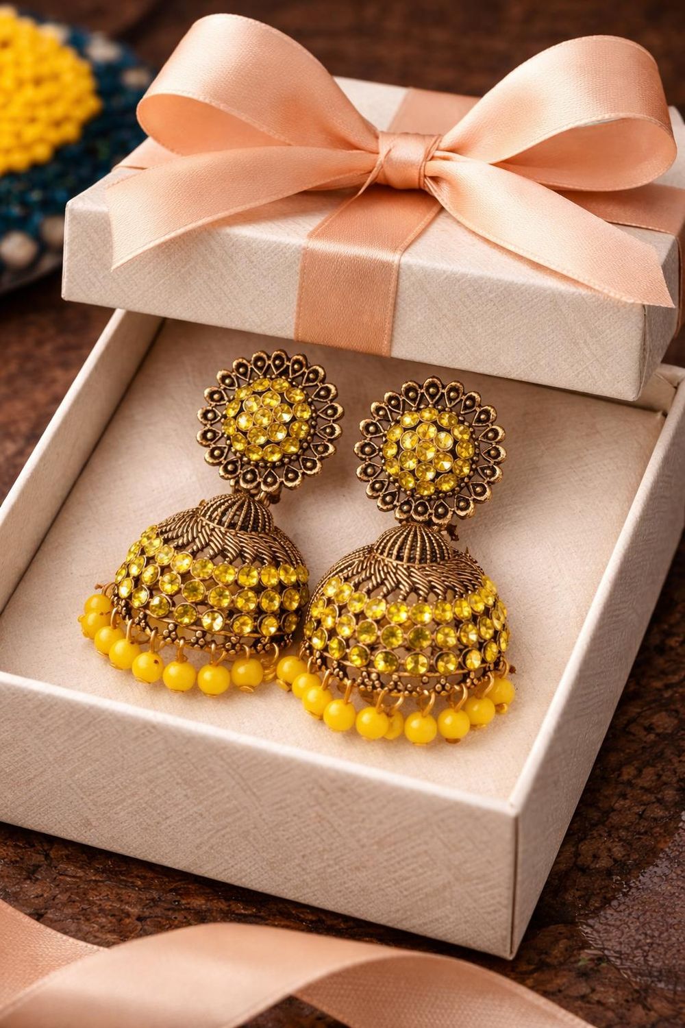 Yellow and  gold tone jhumka earrings with stone domes