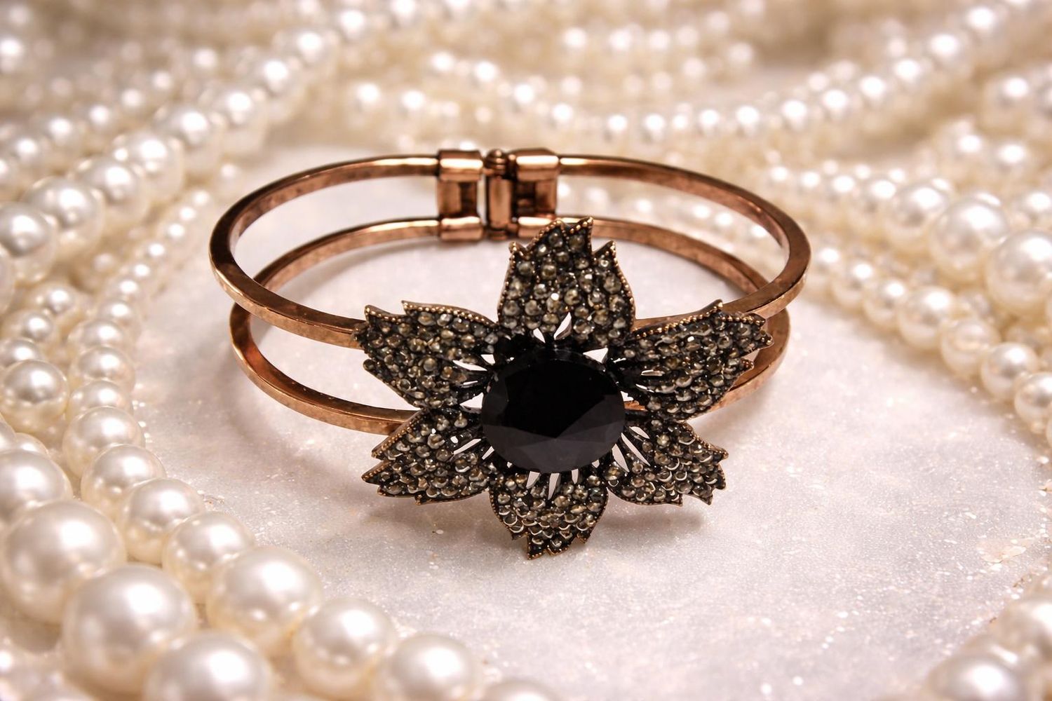 Gold-tone bangle with black flower