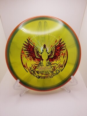 Axiom Discs- Prism Proton Envy - Team Series - Rebirth Eagle McMahon. Greenish/Tan opaque with Orange Sparkly Rim 174g