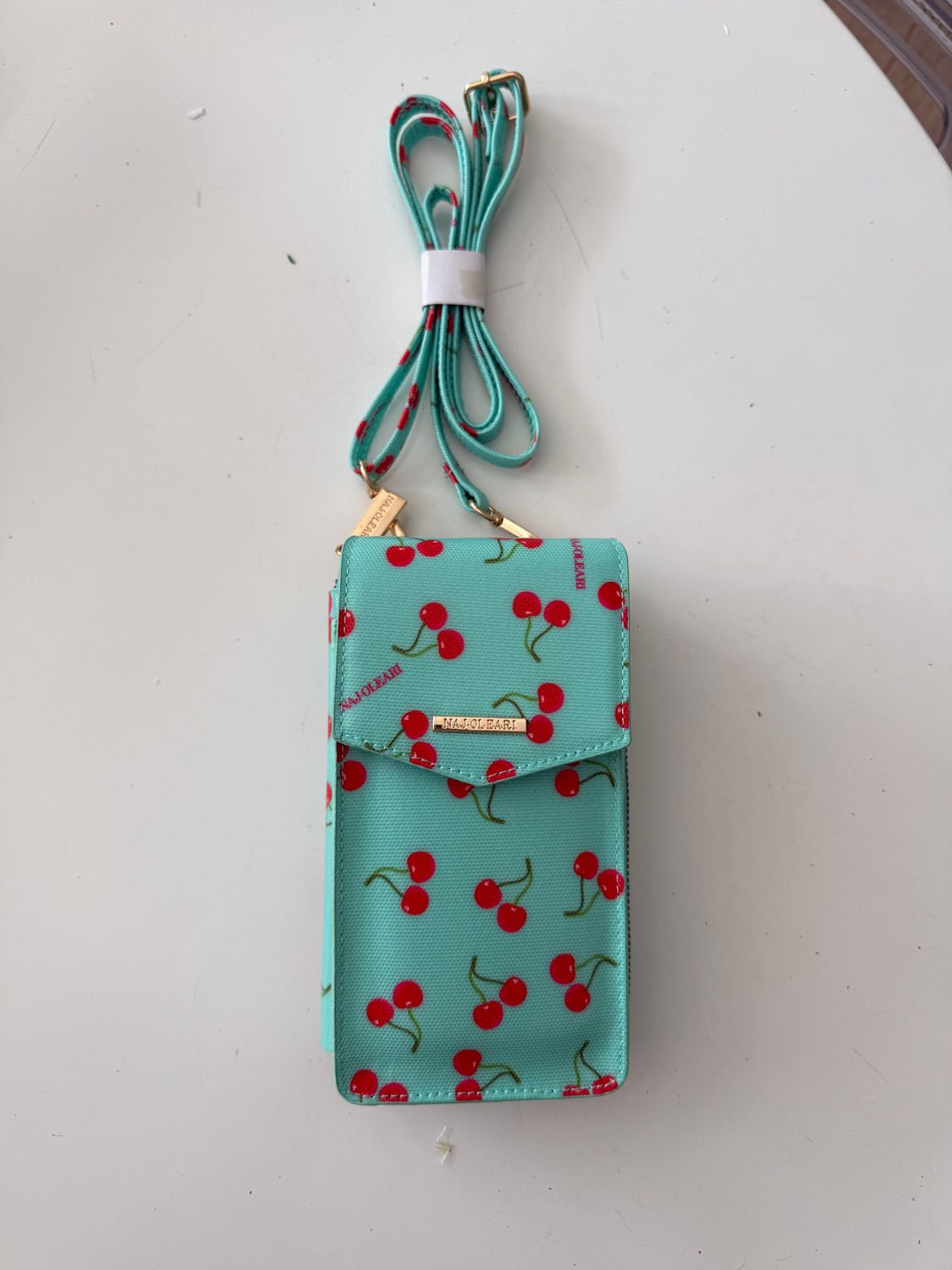 ​Porta cellulare e portafoglio con tracolla azzurra con ciliegie - Naj Oleari ​Porta cellulare e portafoglio con tracolla azzurra con ciliegie - Naj Oleari