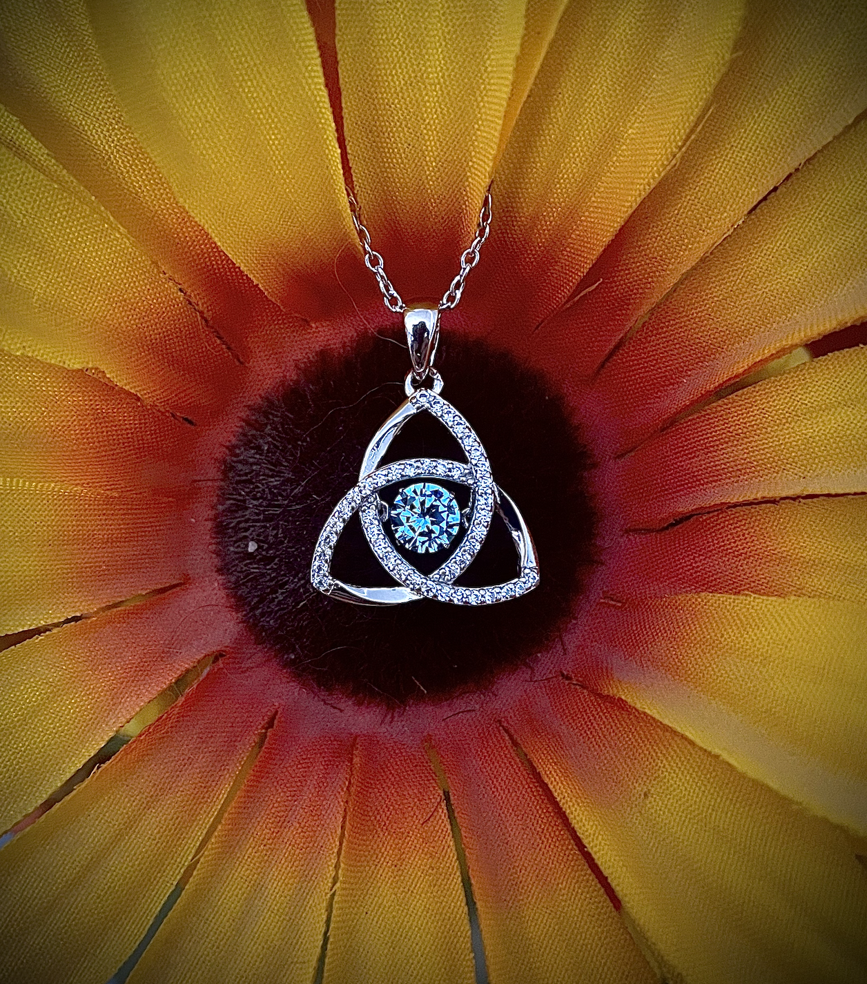 Trinity Dancing Stone Sterling Silver Trinity Knot Pendant with Aquamarine Stone on sunflower