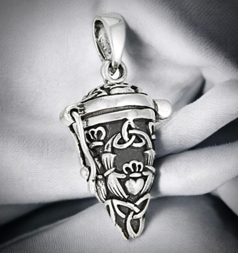 Secret Latching Silver Trinity Knot and Claddagh Vial Locket Pendant Sterling silver vial locket pendant necklace with Celtic trinity knot design, handcrafted jewelry, on grey fabric.