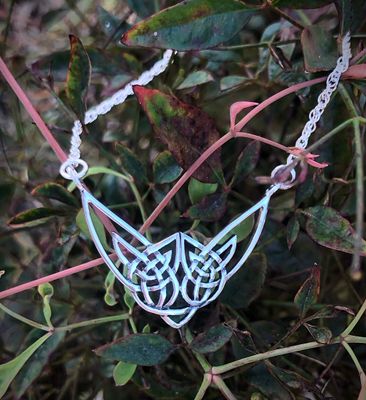 Scottish Highland Cow sterling silver necklet, handcrafted jewelry from Scotland, shown by plants.