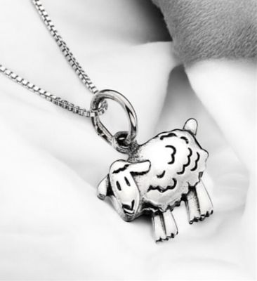 Sterling Silver Sheep Pendant Necklace on white fabric.