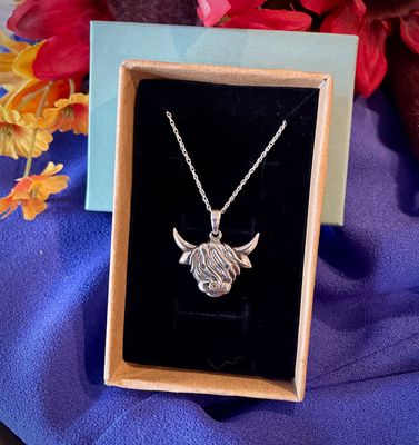 Sterling silver Scottish Highland Cow pendant, handcrafted Celtic jewelry from Scotland, shown in jewelry box. 