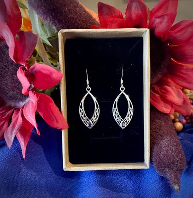 Sterling silver oval earrings featuring intricate Celtic knots and a radiant amethyst-colored stone, inspired by Scotland.
