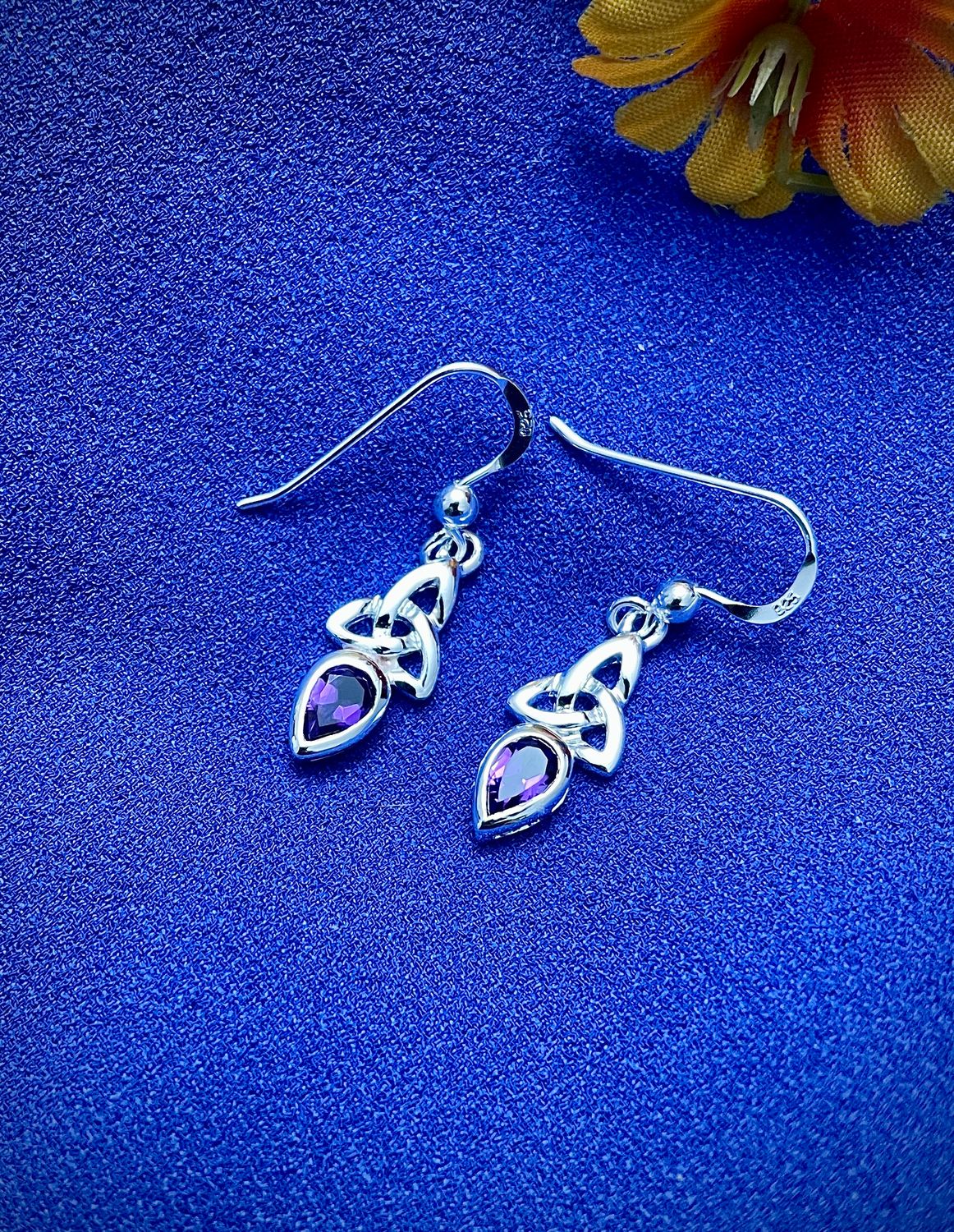 Irish-inspired sterling silver earrings with Trinity Knot design and sparkling amethyst-colored stones.