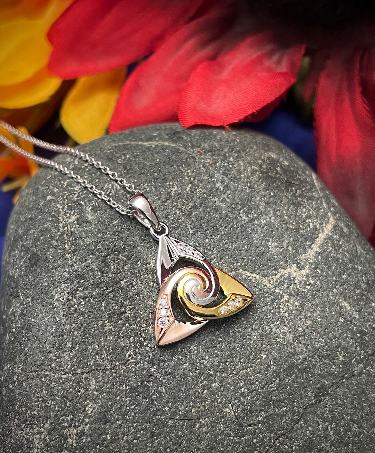 Trinity Spiral Center Tri-Color with CZ Stones Sterling silver Trinity knot with rose gold plating and CZ stones, Irish-inspired pendant necklace on stone.