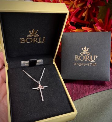 Celtic cross necklace in sterling silver featuring a rose gold plated Trinity knot centerpiece. Made in Ireland by Boru. 