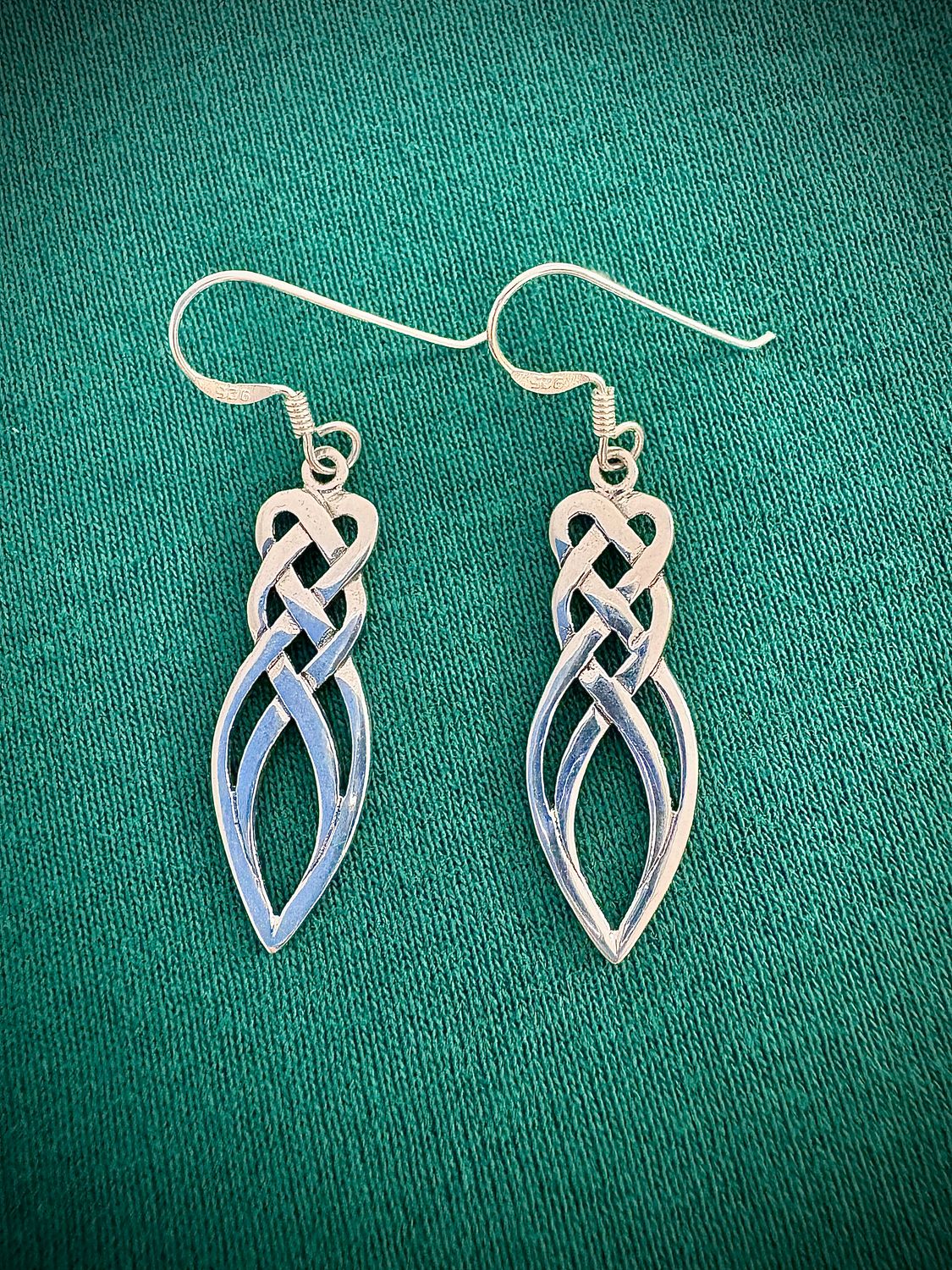 Sterling Silver Celtic Knot Drop Earrings on Green Fabric.