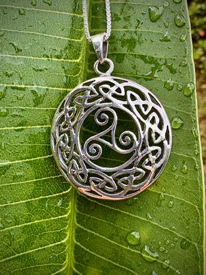 Triskele in Celtic Knotwork Pendant Sterling Silver Celtic Knotwork Pendant with Triskele symbol, representing everlasting motherly love, shown on leaf.