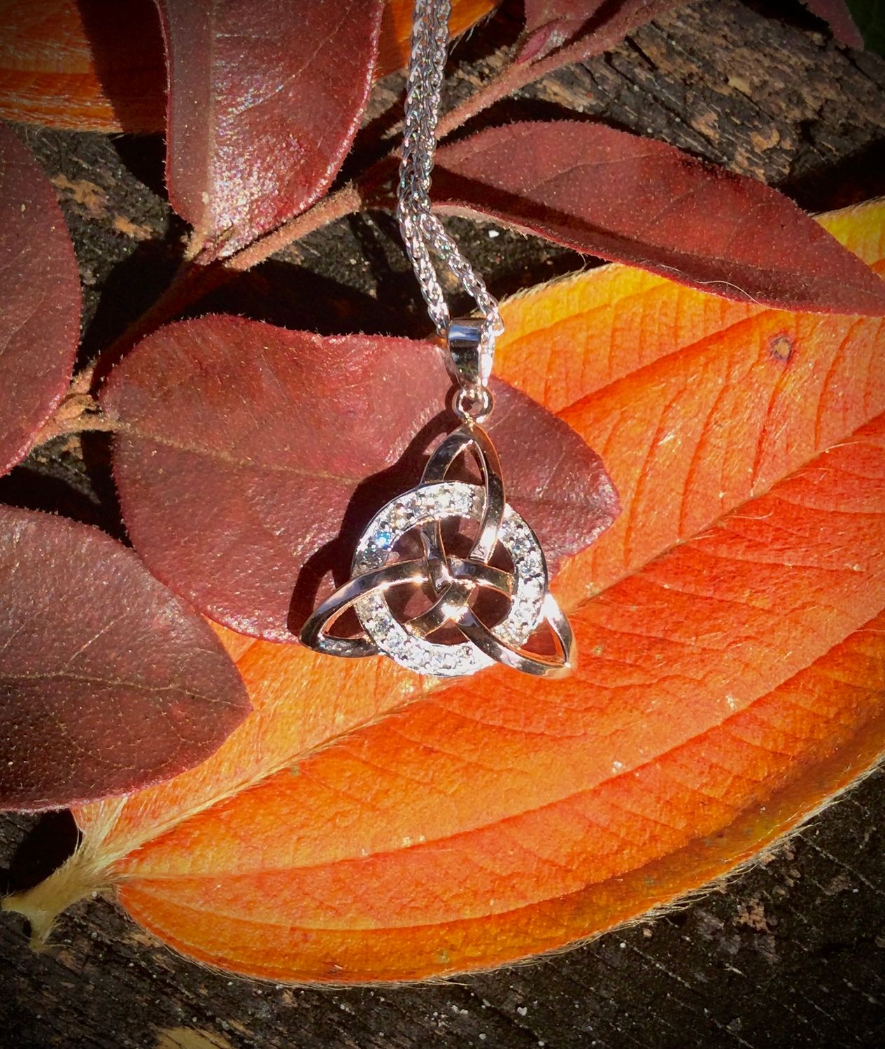 Sterling silver Trinity Knot necklace with rose gold plating and sparkling CZ circle stone set, handcrafted Celtic pendant.