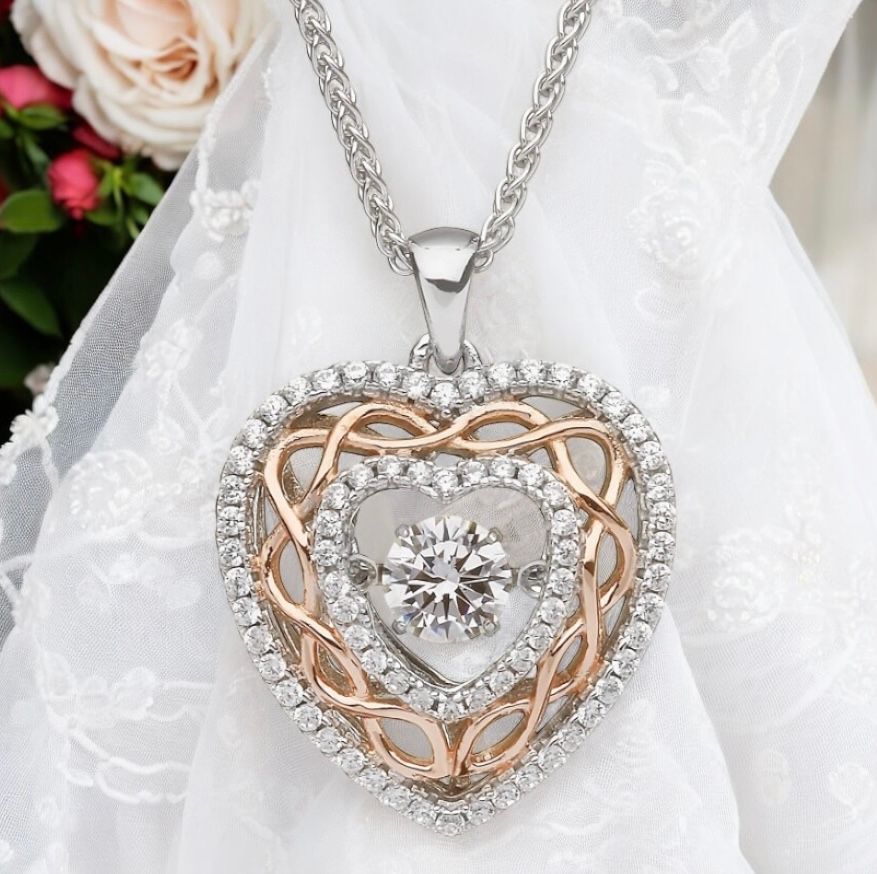 Dancing Stone Heart Pendant with Celtic Knots Sterling silver Celtic heart pendant with rose gold plated knotwork and sparkling CZ stone, celebrating Celtic heritage.