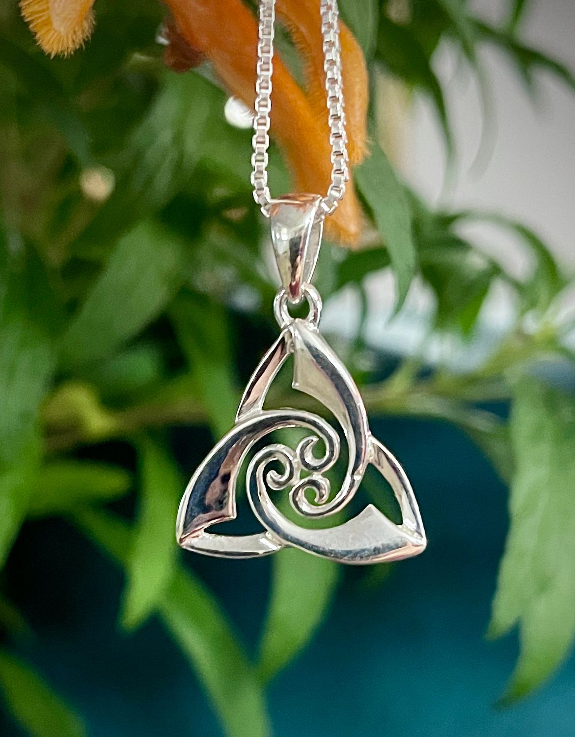 Irish-inspired sterling silver Trinity Knot pendant featuring intricate Celtic knotwork and swirl motif.