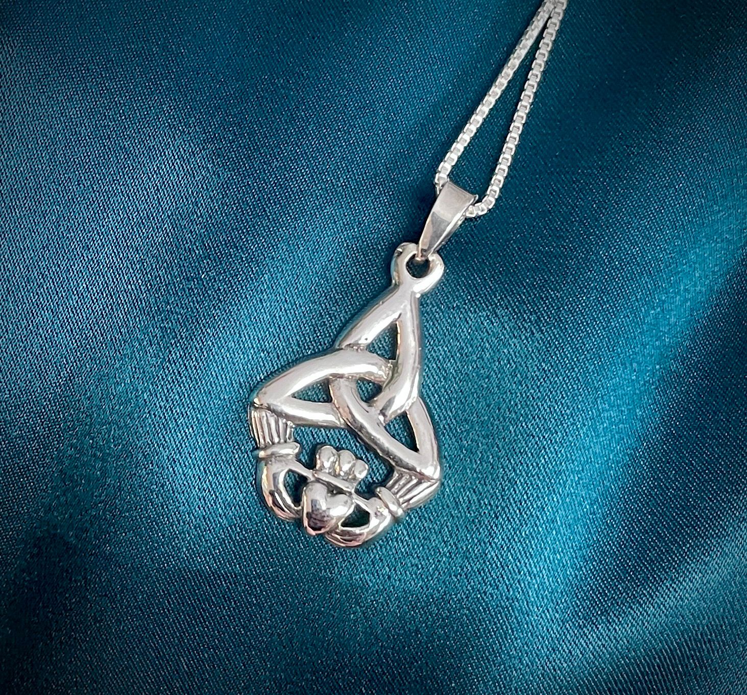 Irish-inspired sterling silver Trinity Knot and Claddagh pendant, symbolizing love, loyalty, and heritage.