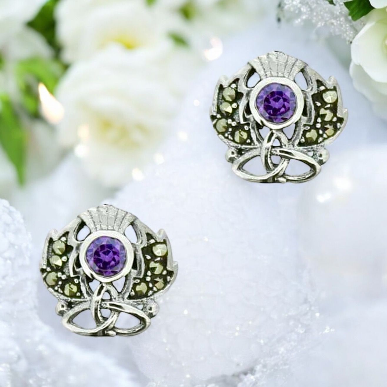 Sterling silver thistle earrings with central marcasite stone and intricate Trinity knot design.
