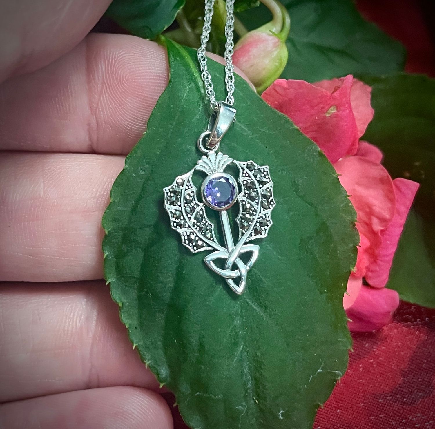 Sterling silver Scottish thistle pendant featuring a Trinity Knot and sparkling marcasite stone, on leaf