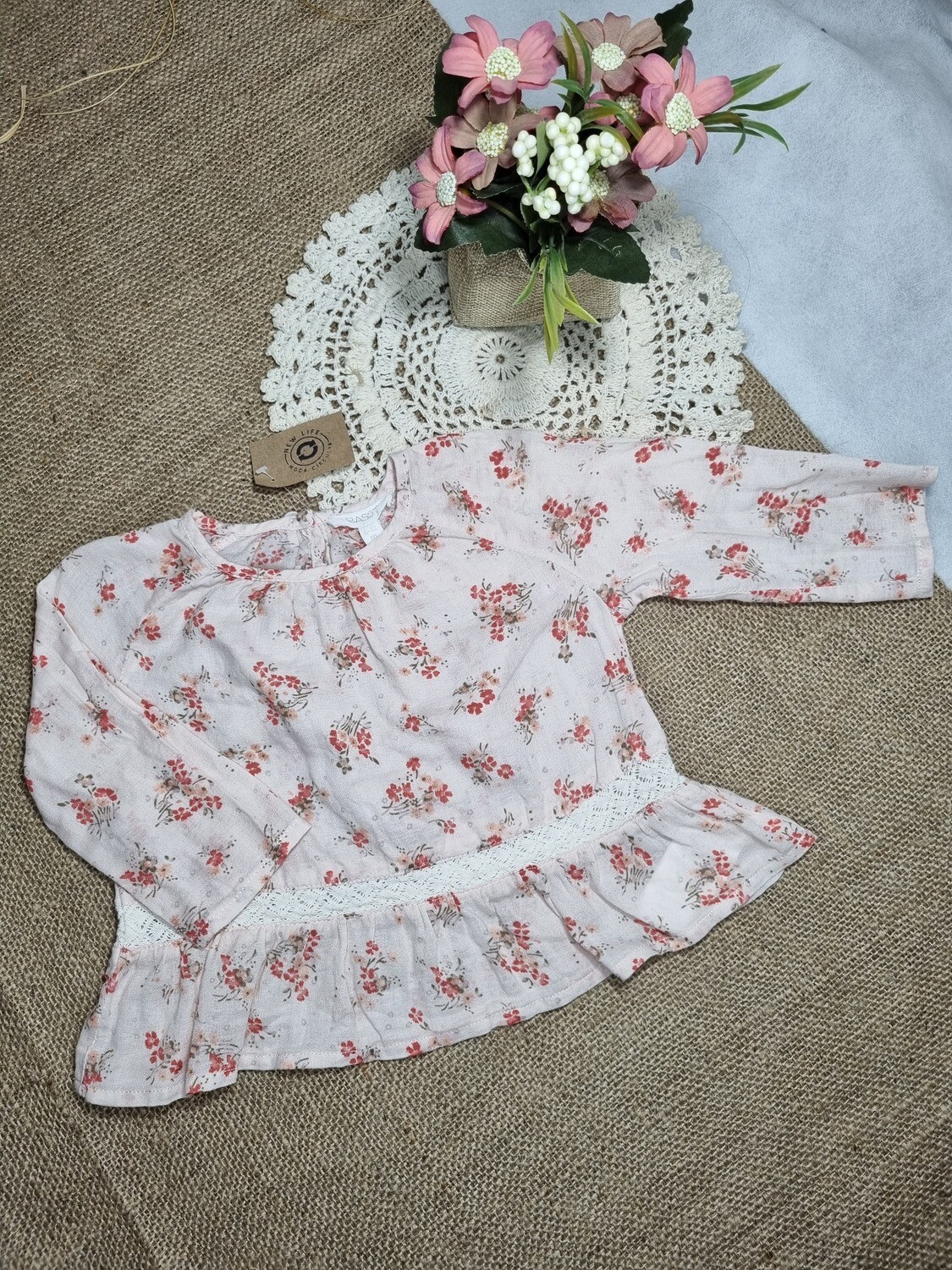 BLUSA ESTAMPADA, COLOR ROSA CON FLORCITAS Y PUNTILLA CON VOLADITO, MANGA LARGA, MARCA BASS, TALLE 6/12 MESES