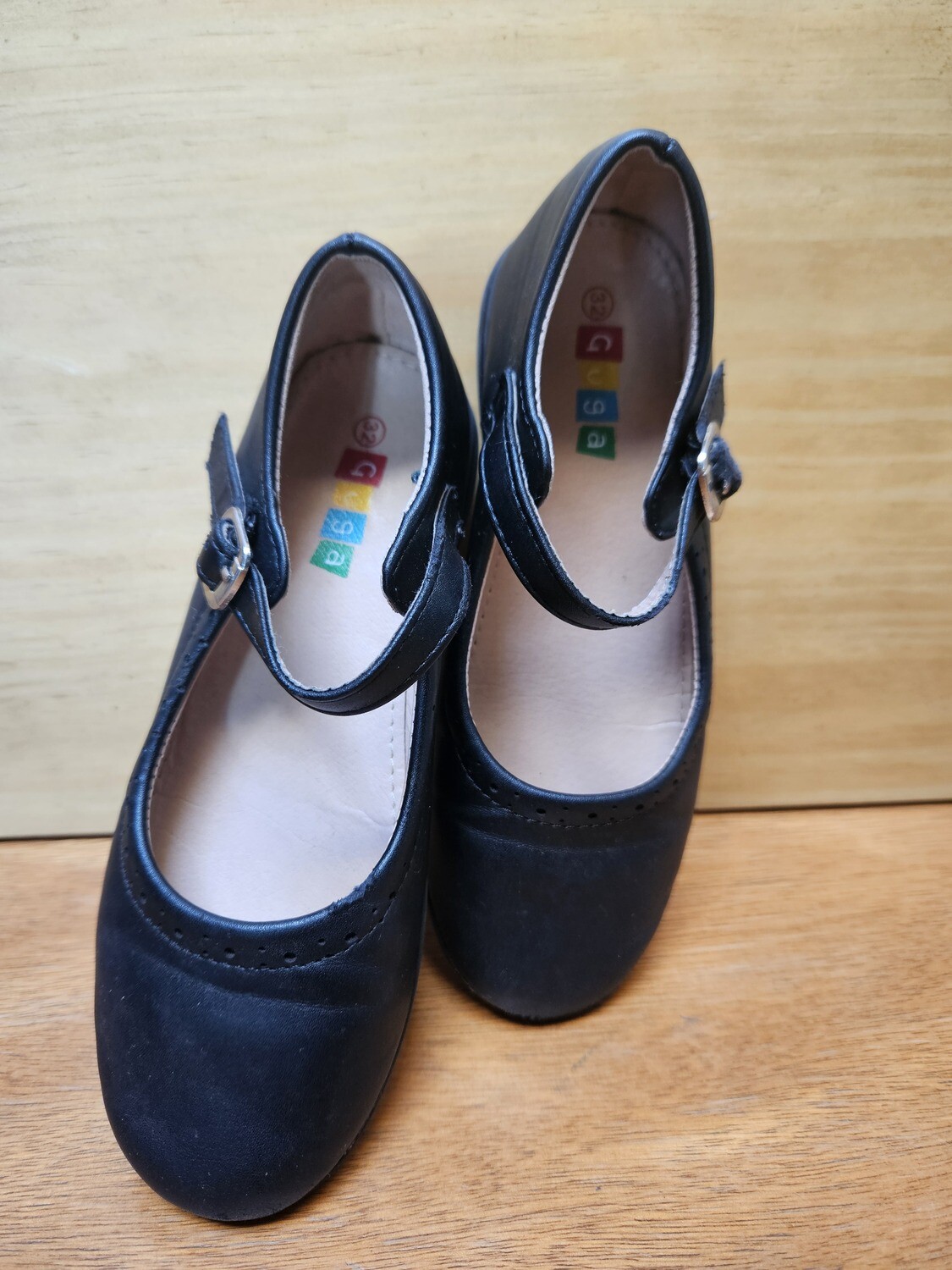 GUILLERMINA EN CUERO COLOR NEGRO, MARCA GUGA, TALLE 32. CON PEQUEÑO DETALLE EN UNA DE LAS PUNTAS.