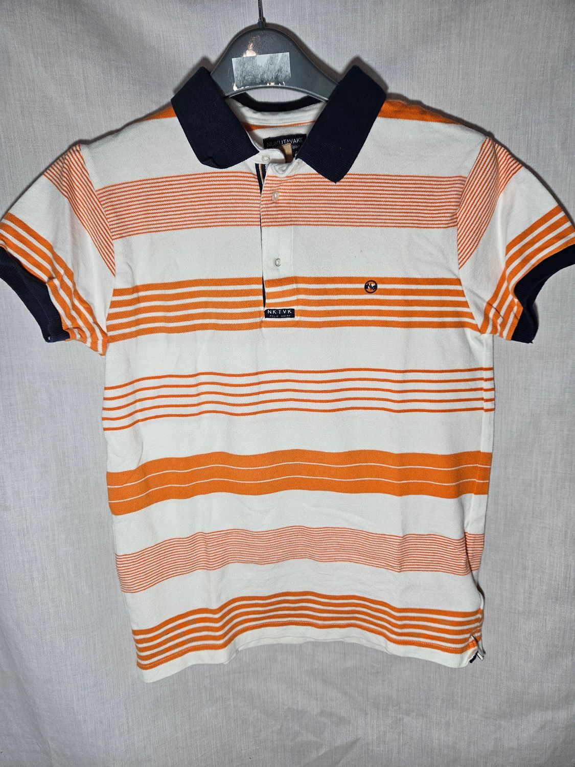 REMERA TIPO CHOMBA, MANGA CORTA, CON CUELLO CON BOTONES. RAYADA BLANCA Y NARANJA. TALLE 14 AÑOS. IMPECABLE