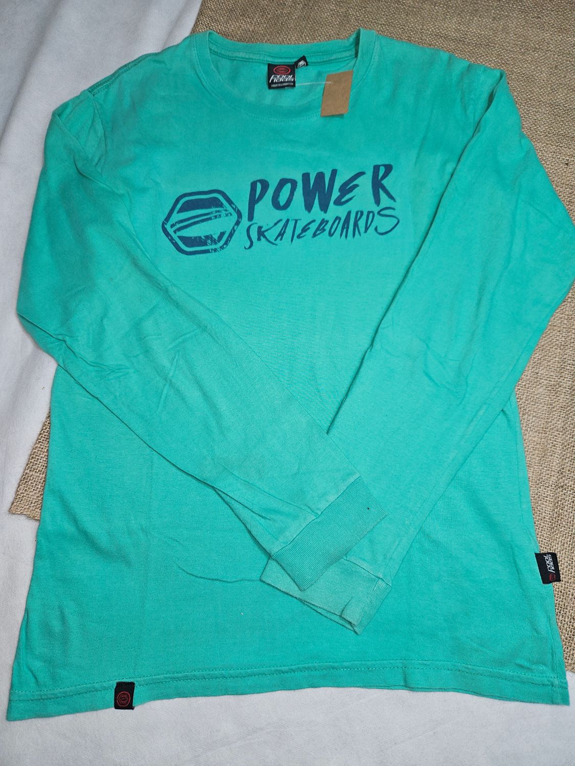 REMERA DE ALGODÓN, MANGA LARGA, TALLE 16. COLOR VERDE CON ESTAMPA DE LETRAS EN AZUL EN FRENTE.