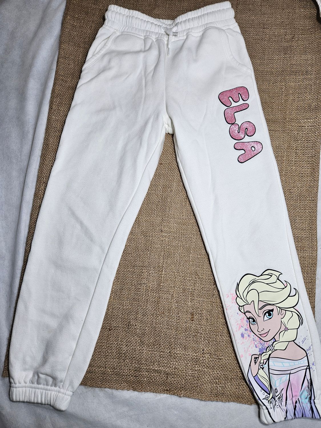 PANTALON DEPORTIVO, PARA NIÑA, CON FELPA, COLOR BLANCO, CON DISEÑO ELSA FROZEN. TALLE 7-8