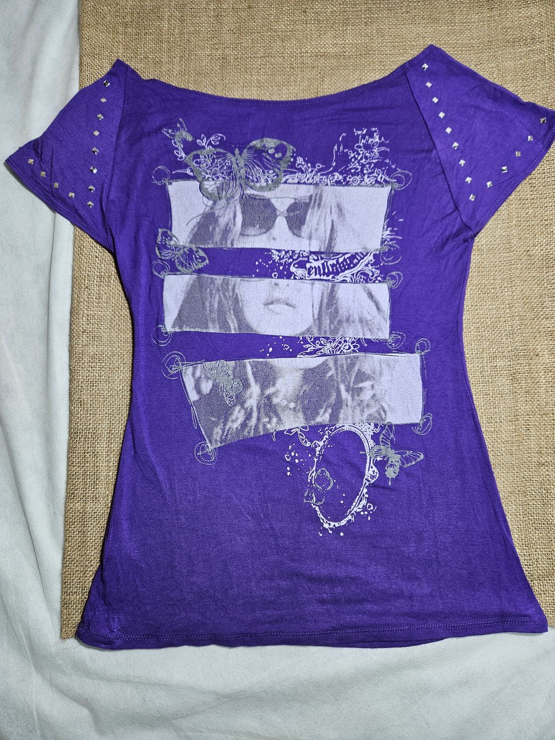 REMERA DE ALGODÓN, MANGA CORTA, PARA DAMA, CON ESTAMPADO EN EL FRENTE, Y TACHAS EN MANGAS. COLOR VIOLETA. TALLE M.