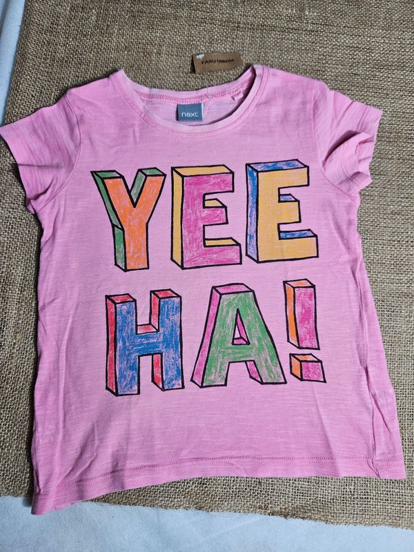 REMERA DE ALGODÓN, MANGA CORTA, PARA NIÑA, COLOR ROSADO, CON ESTAMPA YEEHA!. MARCA NEXT. TALLE 6