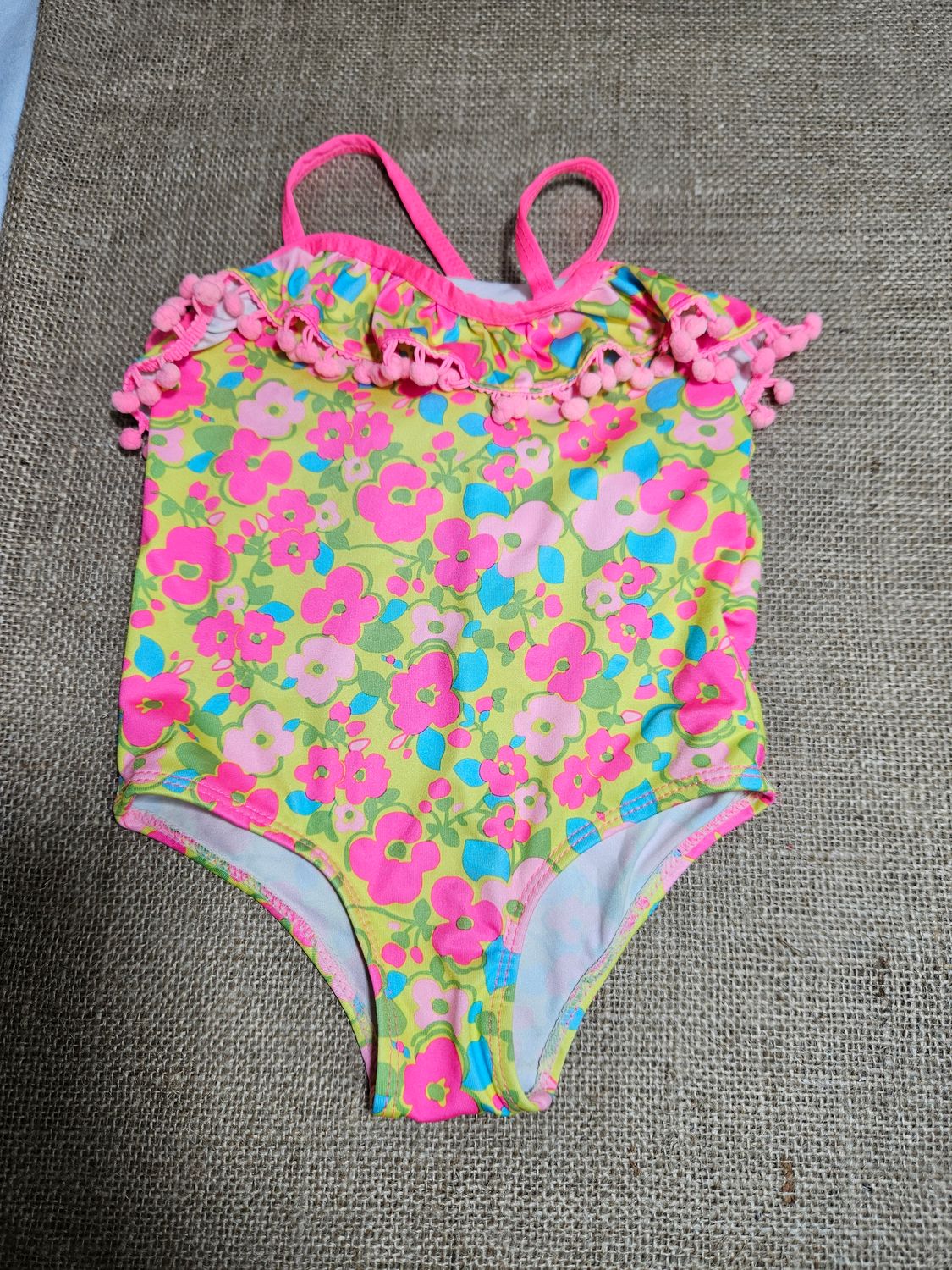 MALLA PARA NIÑA, CON VOLADO Y BORLAS EN EL FRENTE. ESTAMPADA. TALLE 24 MESES. MARCA PINK PLATINUM